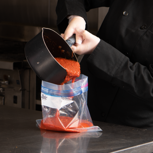 Image of stand up stay open Ziploc bag being filled with sauce