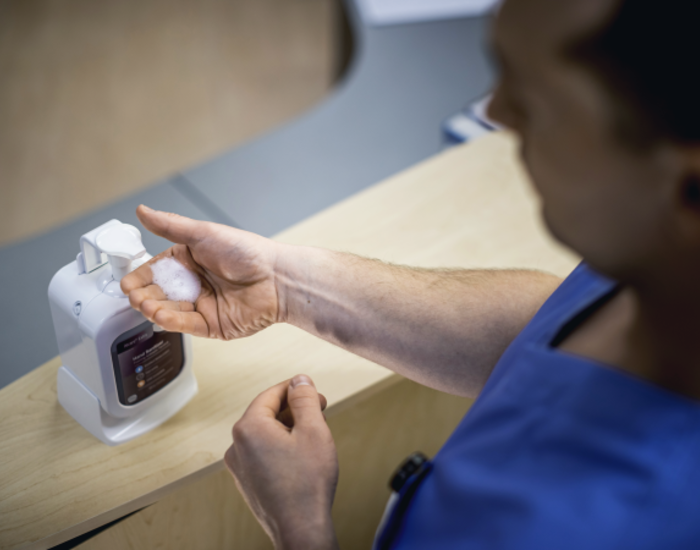 Image showing person using hand sanitizer in healthcare setting